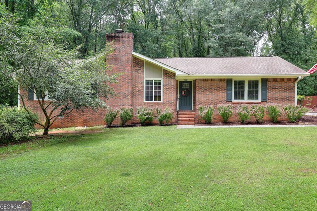 241 Lavern Ct, Winder, GA 30680 - ranch-style house with a front yard, a chimney, entry steps, and brick siding