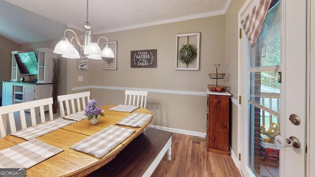 241 Lavern Ct, Winder, GA 30680 - dining area featuring a chandelier, wood finished floors, and crown molding