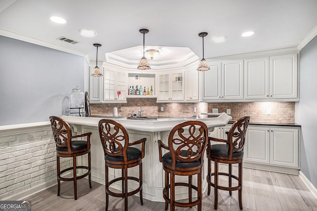 1155 Admiral Xing, Alpharetta, GA 30005 - kitchen featuring light wood finished floors, ornamental molding, white cabinets, a kitchen breakfast bar, and glass insert cabinets