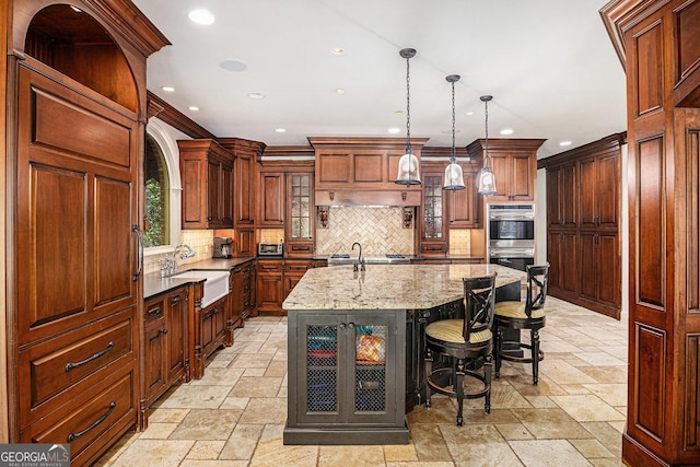 1155 Admiral Xing, Alpharetta, GA 30005 - kitchen featuring stone tile floors, double oven, recessed lighting, backsplash, and an island with sink