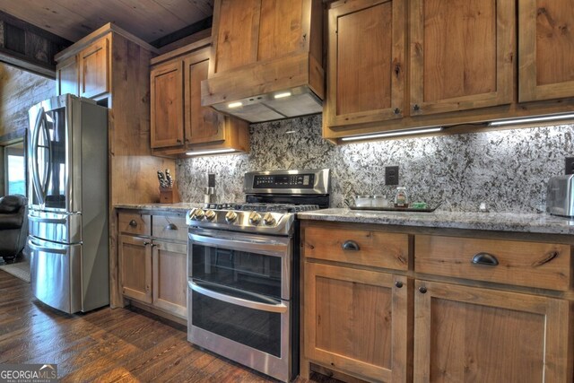 330 Serenity Ridge Ln, Mineral Bluff, GA 30559 - kitchen featuring stainless steel appliances, premium range hood, dark wood-style floors, backsplash, and brown cabinets
