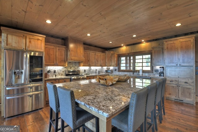 330 Serenity Ridge Ln, Mineral Bluff, GA 30559 - kitchen with stainless steel appliances, wood ceiling, brown cabinetry, a breakfast bar area, and dark wood-style floors