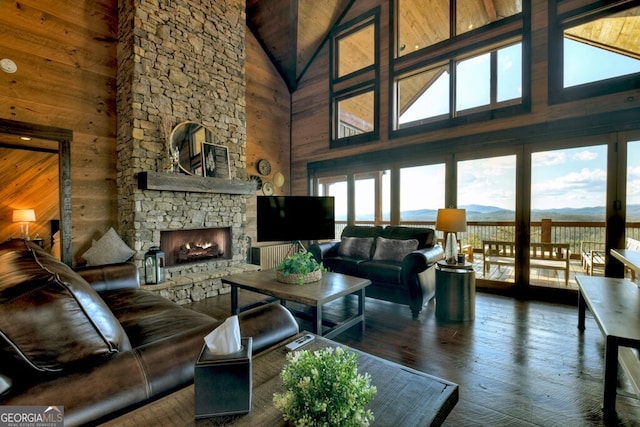 330 Serenity Ridge Ln, Mineral Bluff, GA 30559 - living room featuring high vaulted ceiling, wooden walls, a stone fireplace, and wood-type flooring