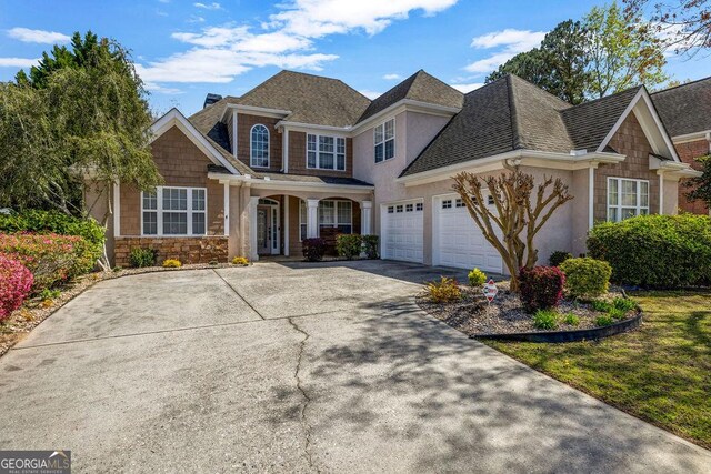 269 Legends Trce, Mcdonough, GA 30253 - view of front facade featuring concrete driveway, a garage, stone siding, roof with shingles, and stucco siding