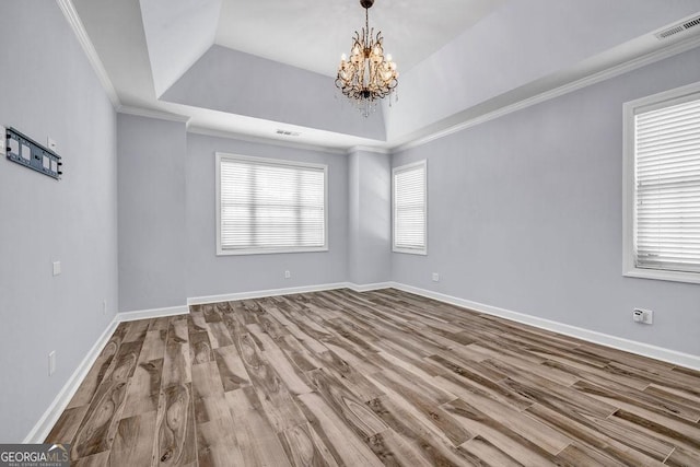 269 Legends Trce, Mcdonough, GA 30253 - empty room with wood finished floors, a chandelier, a raised ceiling, and ornamental molding