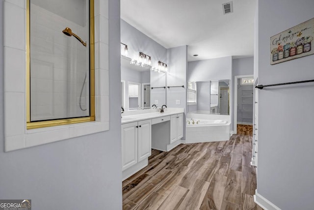 269 Legends Trce, Mcdonough, GA 30253 - bathroom featuring a bath, wood finished floors, double vanity, and tiled shower
