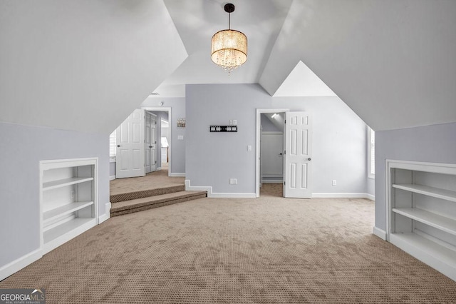 269 Legends Trce, Mcdonough, GA 30253 - additional living space with carpet floors, built in features, vaulted ceiling, and a chandelier