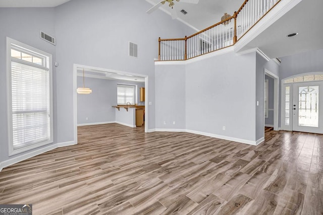 269 Legends Trce, Mcdonough, GA 30253 - unfurnished living room with high vaulted ceiling, wood finished floors, ceiling fan, and ornamental molding