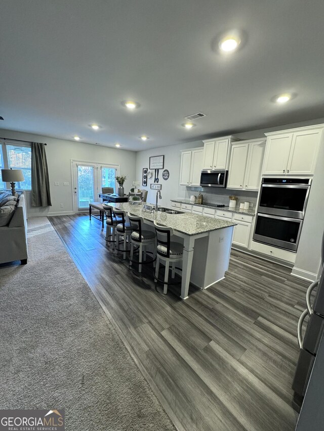 5257 Shorthorn Way, Powder Springs, GA 30127 - kitchen with appliances with stainless steel finishes, open floor plan, recessed lighting, dark wood-style flooring, and a kitchen island with sink