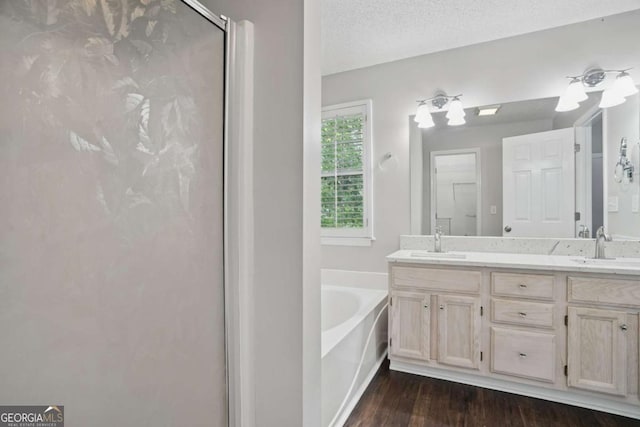 46 Highland Ct, Carrollton, GA 30116 - bathroom featuring a garden tub, double vanity, a shower stall, and wood finished floors