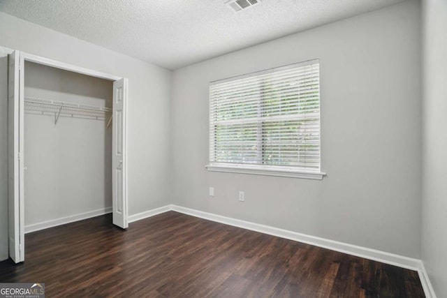 46 Highland Ct, Carrollton, GA 30116 - unfurnished bedroom with dark wood-style floors, a textured ceiling, and a closet