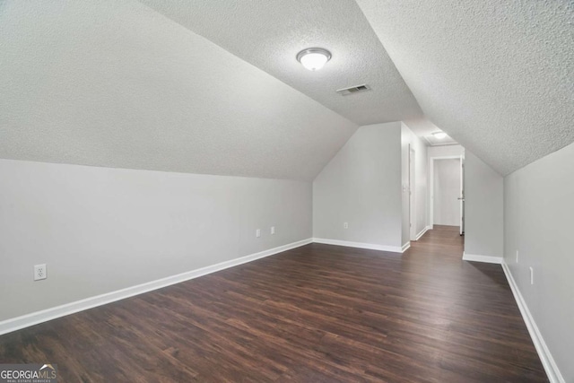46 Highland Ct, Carrollton, GA 30116 - additional living space featuring a textured ceiling, dark wood-type flooring, and vaulted ceiling