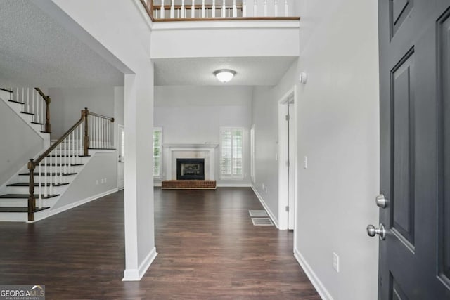 46 Highland Ct, Carrollton, GA 30116 - foyer featuring wood finished floors, stairway, a fireplace, a textured ceiling, and a high ceiling