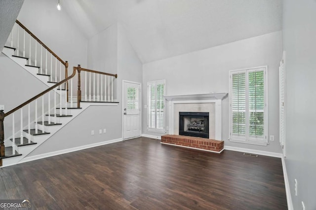 46 Highland Ct, Carrollton, GA 30116 - unfurnished living room with high vaulted ceiling, healthy amount of natural light, stairway, wood finished floors, and a fireplace