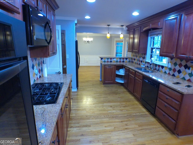 5741 Wolf Laurel Ln SW, Lilburn, GA 30047 - kitchen featuring black appliances, a chandelier, tasteful backsplash, light wood-type flooring, and a peninsula