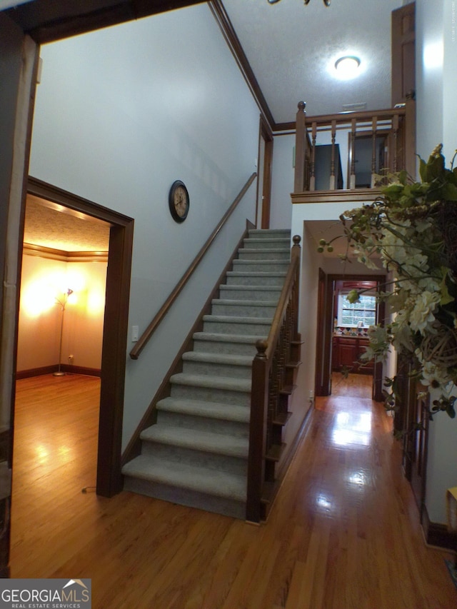 5741 Wolf Laurel Ln SW, Lilburn, GA 30047 - staircase with wood finished floors and ornamental molding