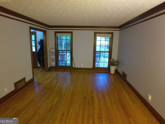 5741 Wolf Laurel Ln SW, Lilburn, GA 30047 - spare room featuring wood finished floors, a textured ceiling, and ornamental molding