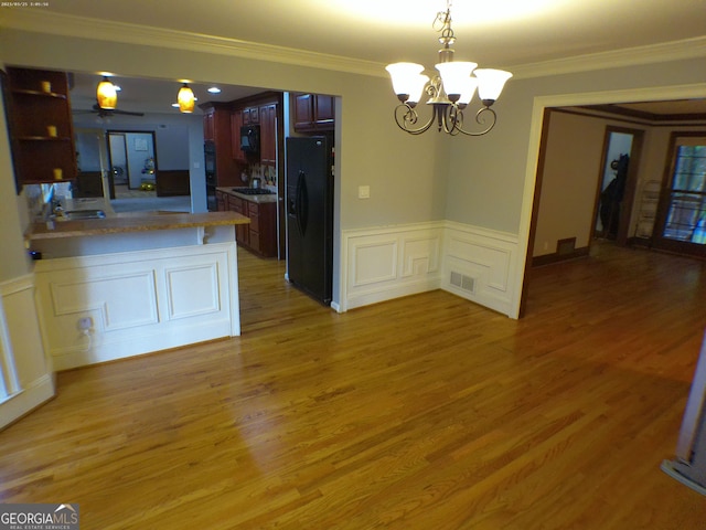 5741 Wolf Laurel Ln SW, Lilburn, GA 30047 - kitchen featuring black refrigerator with ice dispenser, a chandelier, wainscoting, crown molding, and a peninsula