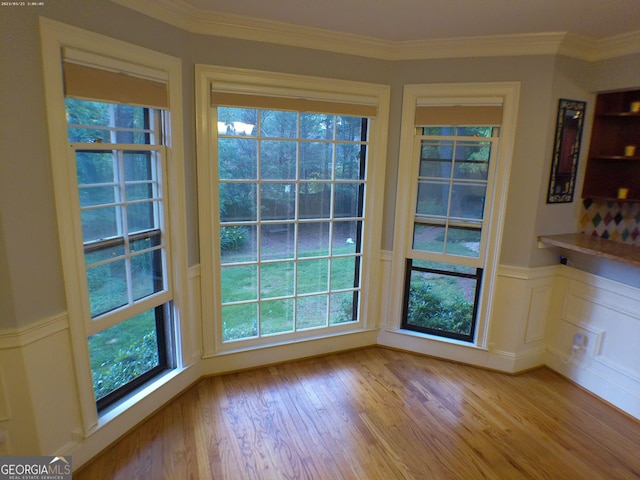 5741 Wolf Laurel Ln SW, Lilburn, GA 30047 - unfurnished dining area featuring light wood-style flooring, a wainscoted wall, and ornamental molding