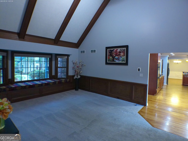 5741 Wolf Laurel Ln SW, Lilburn, GA 30047 - unfurnished living room with high vaulted ceiling, beamed ceiling, light wood finished floors, and wainscoting