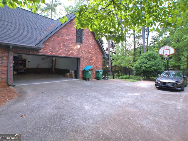 5741 Wolf Laurel Ln SW, Lilburn, GA 30047 - view of side of home with brick siding, asphalt driveway, a shingled roof, and a garage