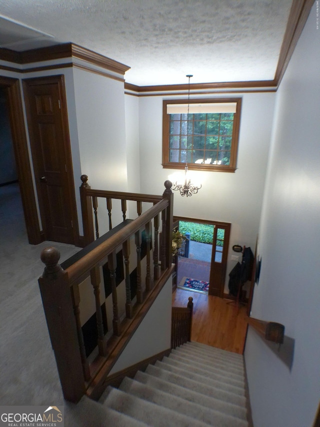 5741 Wolf Laurel Ln SW, Lilburn, GA 30047 - stairs with a chandelier, a textured ceiling, and ornamental molding