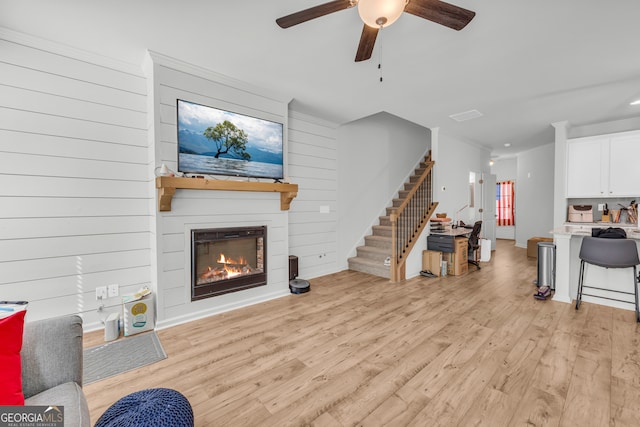 5615 Parkview Ln, Flowery Branch, GA 30542 - living area featuring stairway, a ceiling fan, light wood-style floors, and a large fireplace