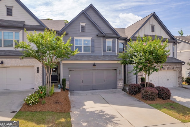 5615 Parkview Ln, Flowery Branch, GA 30542 - view of front of house with board and batten siding, an attached garage, driveway, and stone siding