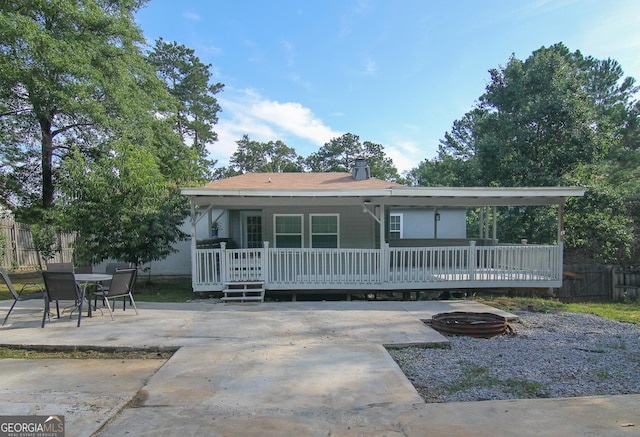 711 Main St, Byron, GA 31008 - view of front of property with a patio, an outdoor fire pit, a deck, and a chimney