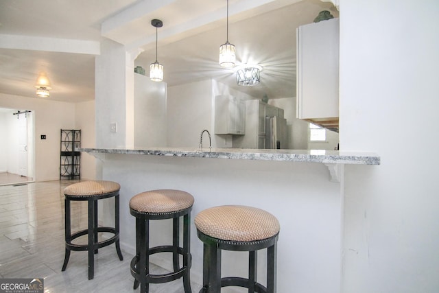 711 Main St, Byron, GA 31008 - kitchen with high end fridge, a kitchen breakfast bar, a peninsula, and hanging light fixtures