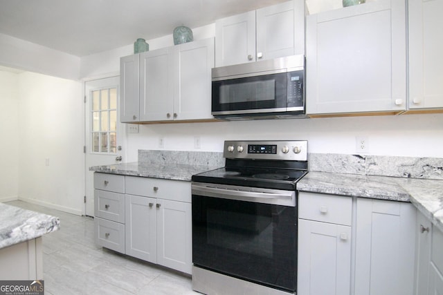 711 Main St, Byron, GA 31008 - kitchen with appliances with stainless steel finishes, light stone countertops, and light tile patterned floors