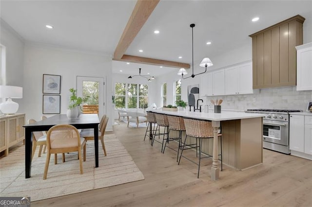 830 Gaston St SW, Atlanta, GA 30310 - kitchen featuring high end stainless steel range, a kitchen island with sink, recessed lighting, light wood-style flooring, and backsplash