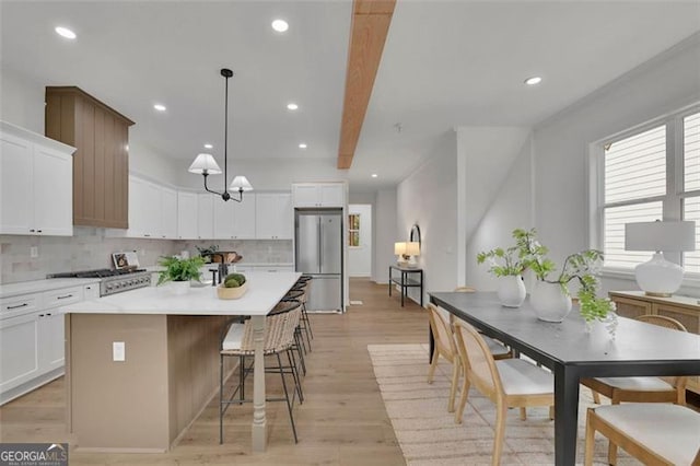 830 Gaston St SW, Atlanta, GA 30310 - kitchen with appliances with stainless steel finishes, a center island, light wood-style flooring, decorative backsplash, and recessed lighting