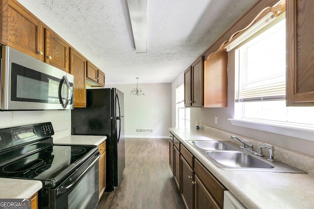 400 Rustin Dr, Dallas, GA 30157 - kitchen with black appliances, dark wood-style floors, light countertops, a textured ceiling, and brown cabinetry