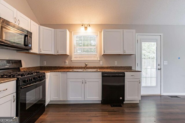 962 Taylors Farm Ct, Canton, GA 30115 - kitchen featuring black appliances, lofted ceiling, dark countertops, healthy amount of natural light, and white cabinetry