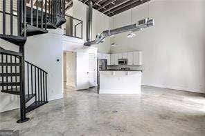 791 Wylie St SE Unit 404, Atlanta, GA 30316 - unfurnished living room featuring a high ceiling, stairway, and concrete flooring