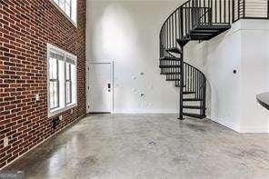 791 Wylie St SE Unit 404, Atlanta, GA 30316 - foyer featuring plenty of natural light, stairs, a high ceiling, and brick wall