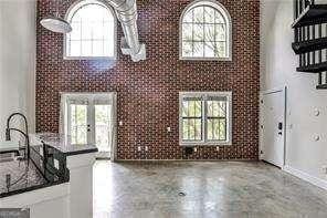 791 Wylie St SE Unit 404, Atlanta, GA 30316 - unfurnished living room featuring plenty of natural light and a high ceiling