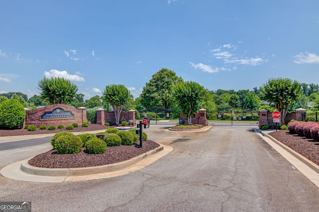 253 Lakeview Bend Cir, Jefferson, GA 30549 - view of asphalt street featuring a gate, curbs, a gated entry, and traffic signs