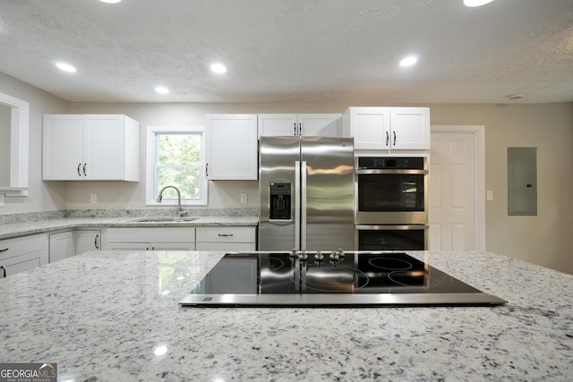 118 Turtle Cove Trwy, Monticello, GA 31064 - kitchen with stainless steel appliances, recessed lighting, electric panel, white cabinetry, and light stone counters