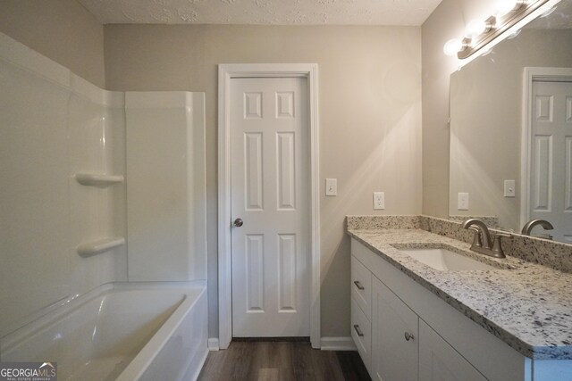 118 Turtle Cove Trwy, Monticello, GA 31064 - bathroom featuring vanity, wood finished floors, shower / washtub combination, and a textured ceiling