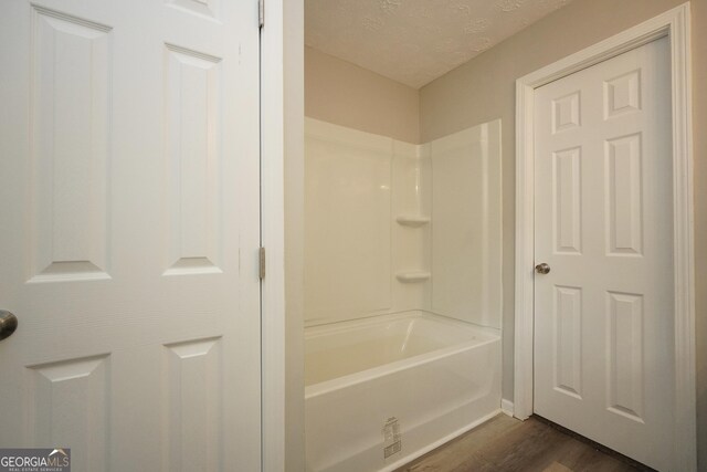 118 Turtle Cove Trwy, Monticello, GA 31064 - full bathroom featuring wood finished floors, a textured ceiling, and shower / bath combination