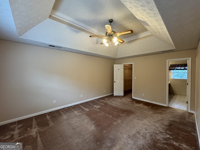 25 Darcee Ct, Lawrenceville, GA 30046 - unfurnished bedroom with a tray ceiling, carpet, a walk in closet, a textured ceiling, and ensuite bathroom