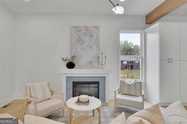 826 Gaston St SW, Atlanta, GA 30310 - living room featuring a tiled fireplace, light wood-style floors, and beamed ceiling