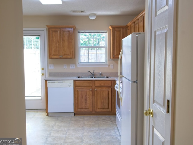 13 Pine Shadow Ct, Centerville, GA 31028 - kitchen with white appliances, light countertops, and brown cabinets