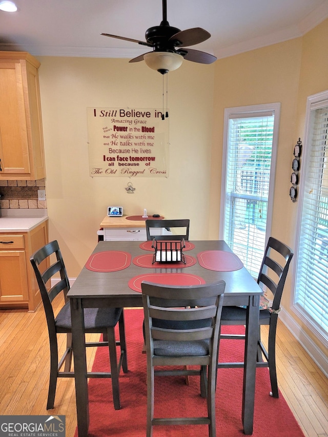 223 Overland Trl, Mcdonough, GA 30252 - dining area featuring light wood-type flooring, ceiling fan, crown molding, and plenty of natural light