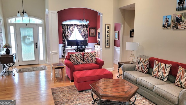 223 Overland Trl, Mcdonough, GA 30252 - living area featuring arched walkways, plenty of natural light, wood finished floors, decorative columns, and a high ceiling