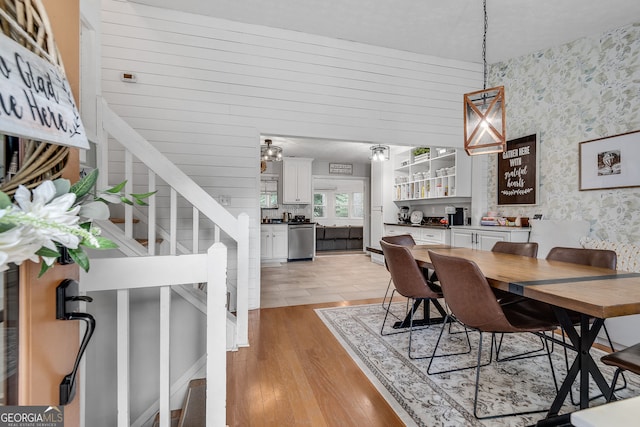 2716 Meadow Ridge Dr NW, Duluth, GA 30096 - dining space with wallpapered walls, light wood-style floors, and stairs