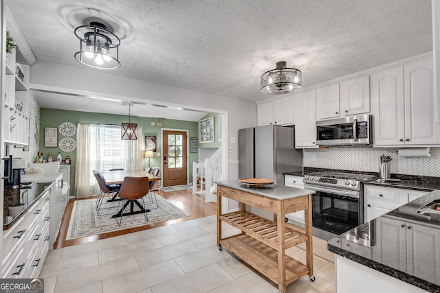 2716 Meadow Ridge Dr NW, Duluth, GA 30096 - kitchen with stainless steel appliances, backsplash, white cabinets, and dark stone counters