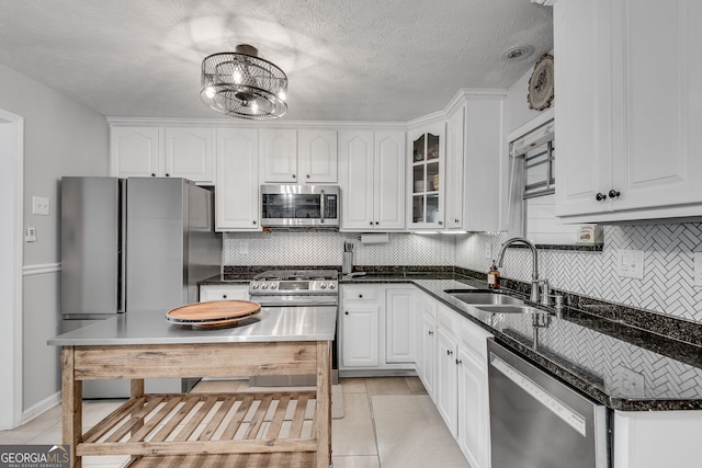 2716 Meadow Ridge Dr NW, Duluth, GA 30096 - kitchen with appliances with stainless steel finishes, tasteful backsplash, white cabinets, light tile patterned floors, and a textured ceiling